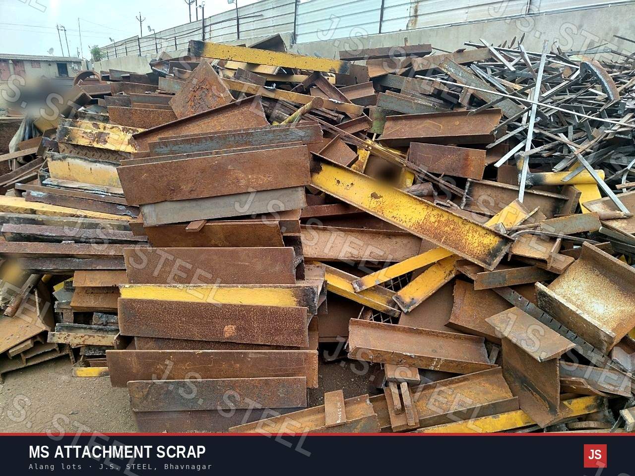 Wide view of an MS attachment scrap heap at the J.S. STEEL yard: cut angles, channels and beams, some painted yellow